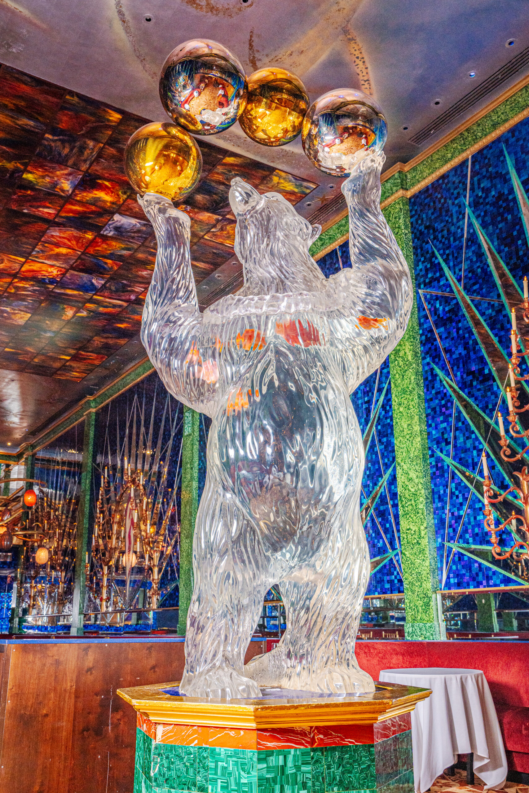080525 – Russian Tea Room-14 Ice sculpture of a bear holding three golden spheres in a colorful setting