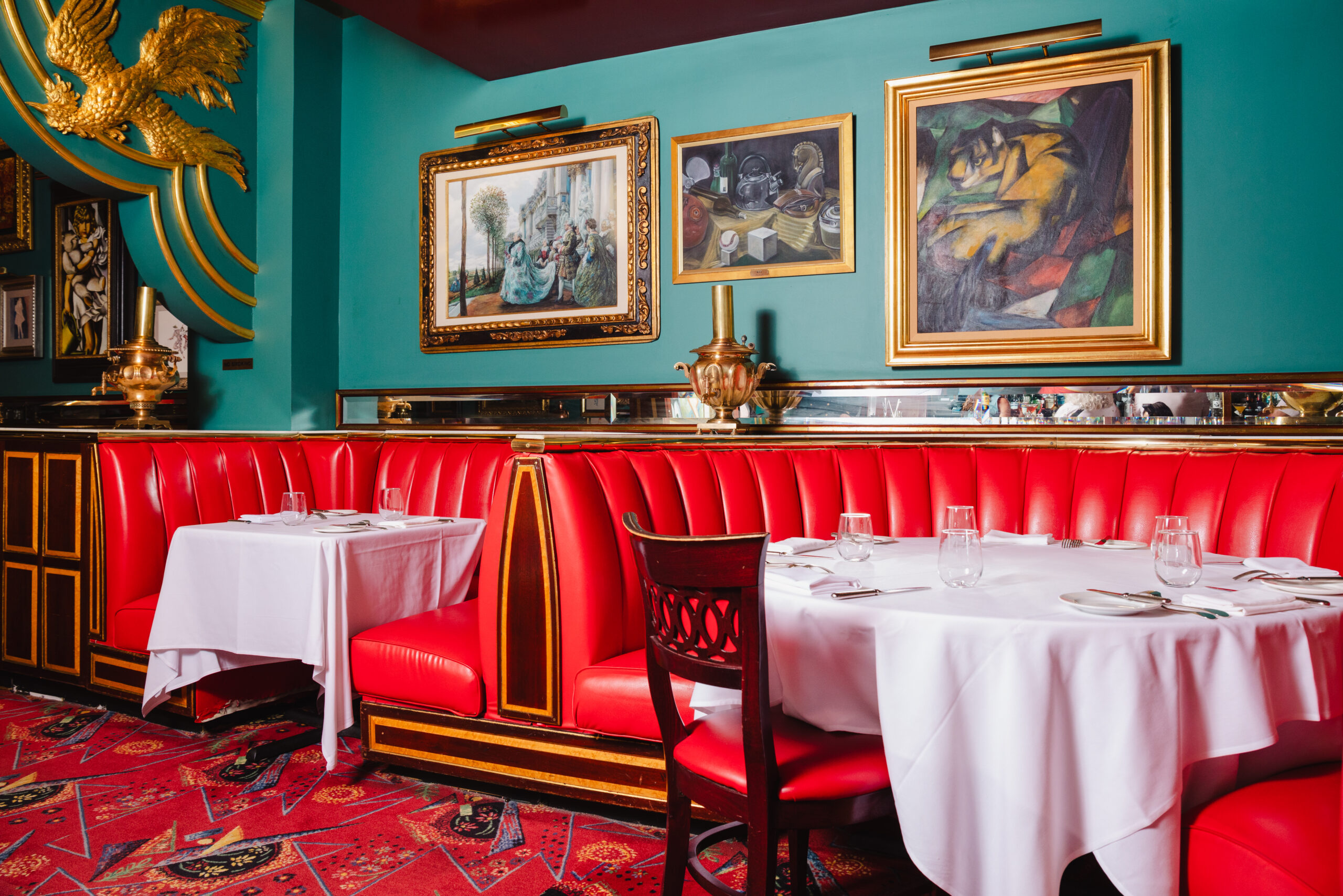 Elegant red booths and white tablecloths in a vibrant restaurant setting