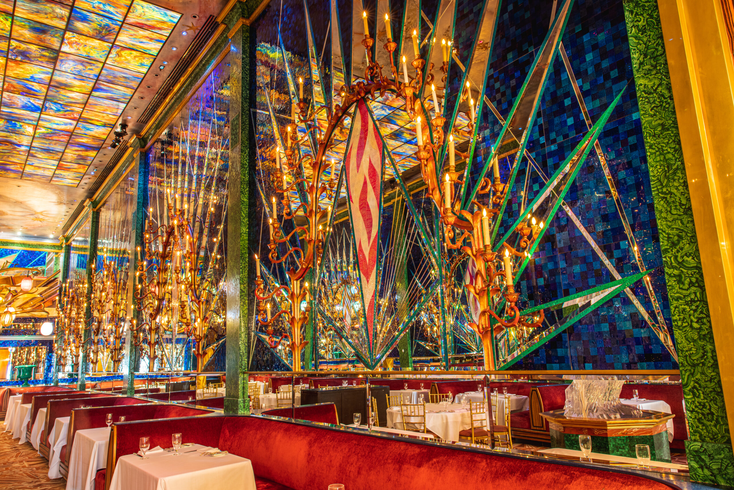 Elegant dining area with red booths and colorful stained glass walls